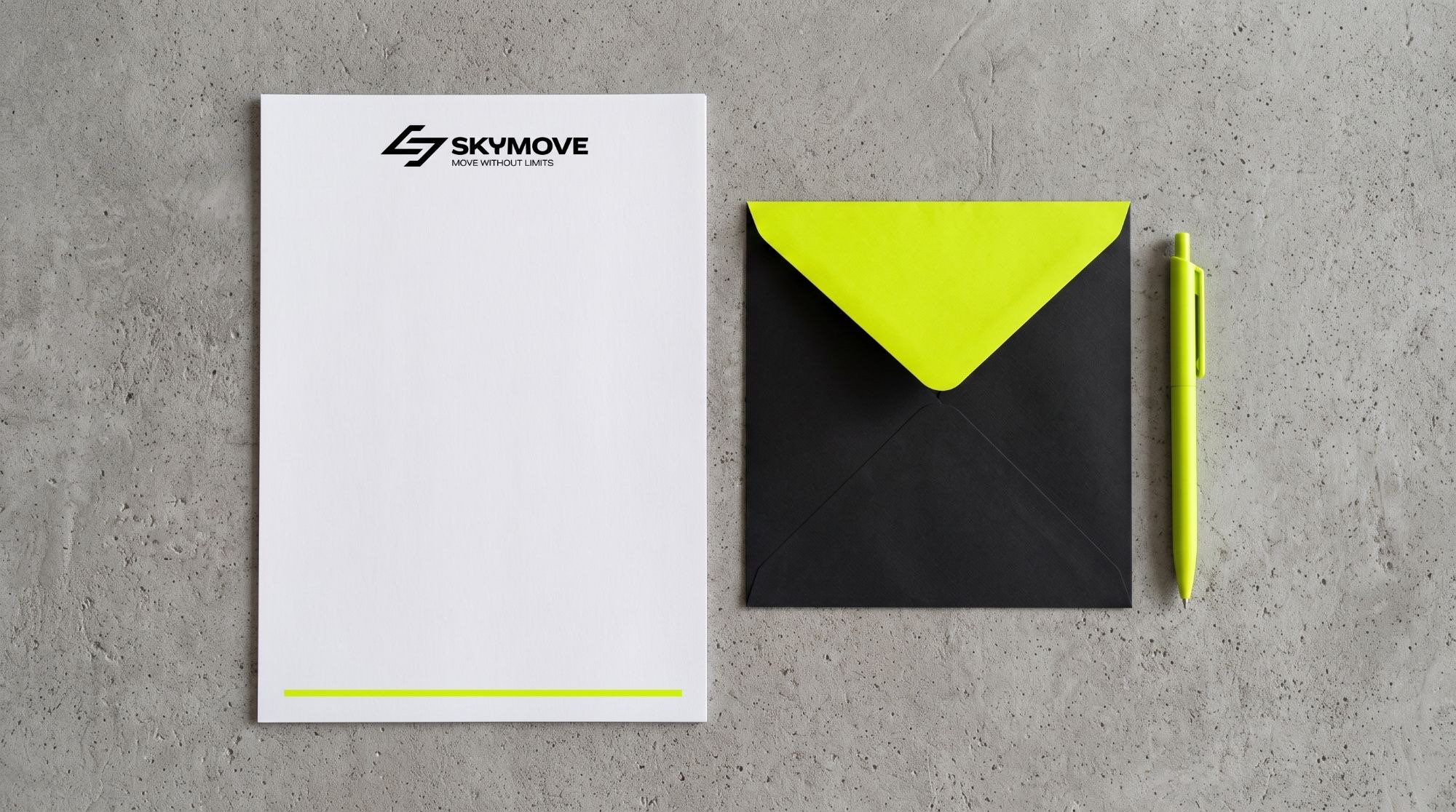 A letterhead, a black envelope with a lime flap and a lime pen on concrete