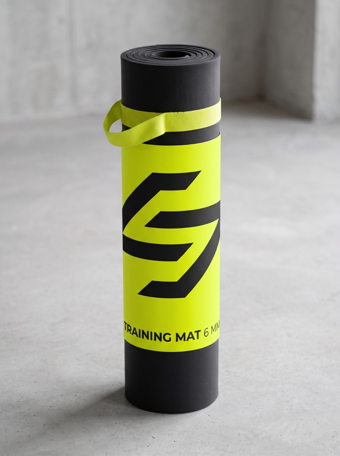 A rolled black training mat in a lime sleeve with a giant mark