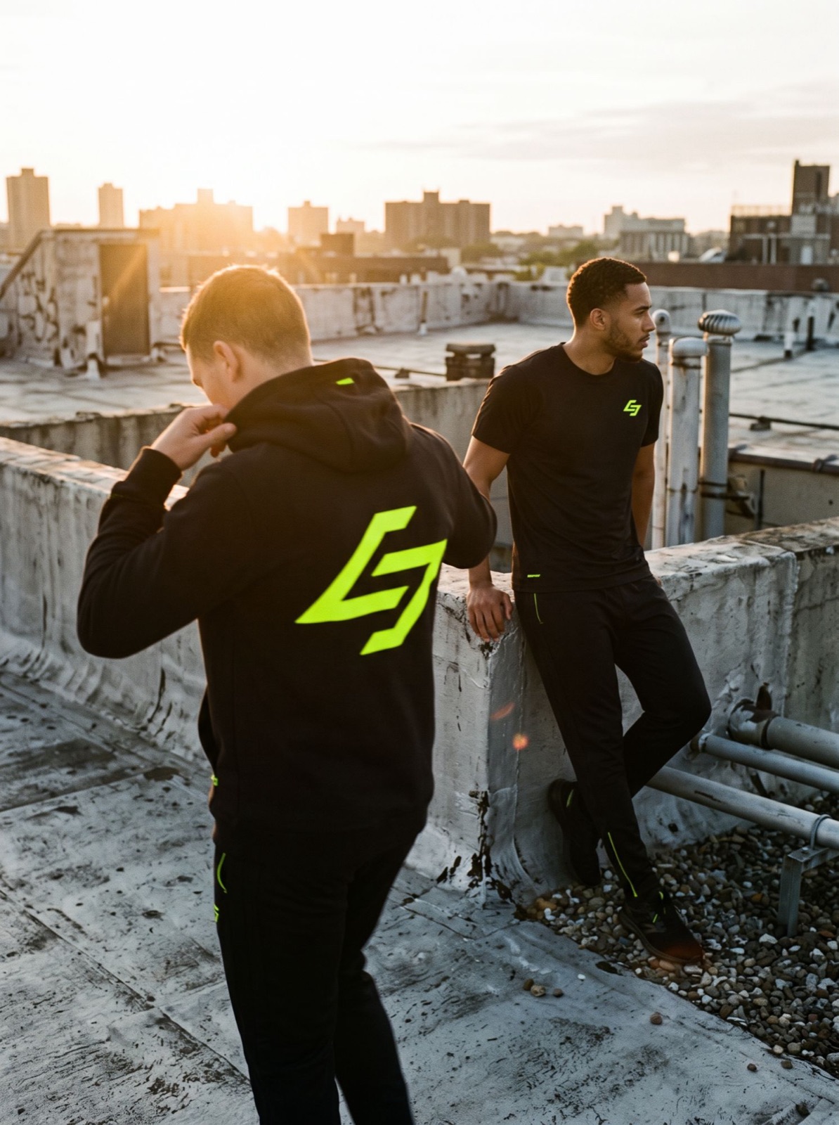 Two people on a rooftop in a black hoodie and a t-shirt with the lime mark