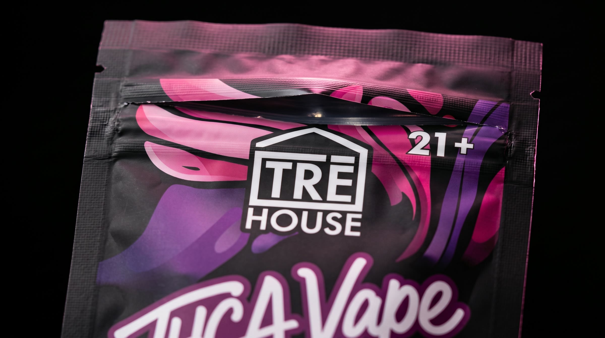 A close-up of the top of the pouch: the TRĒ House logo and 21+ over the pink illustration